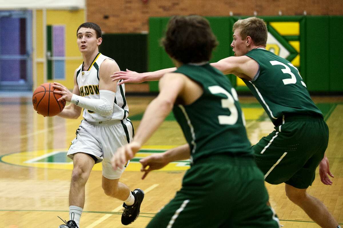 Dow's Ben Zeitler dribbles the ball down the court as Alpena's Chris Derocher reaches out towards him on Tuesday at H. H. Dow High School.