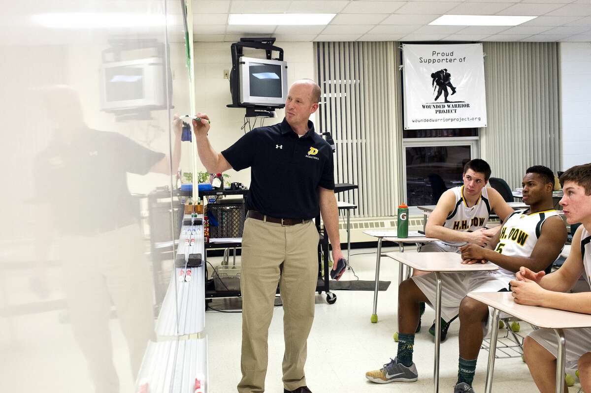 Dow basketball head coach Mark Dickerson talks to his team during the half on Tuesday at H. H. Dow High School.