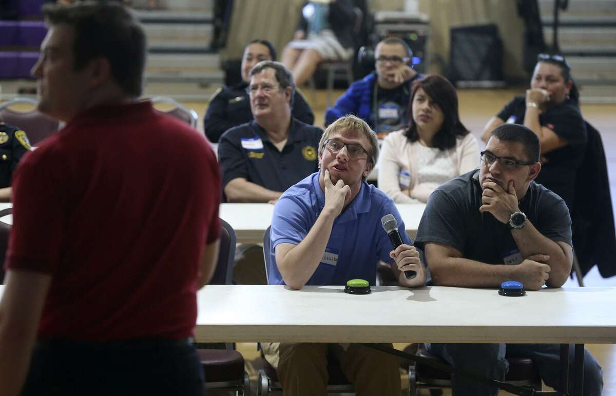Ben Sehlke (center, holding microphone) and Owen Griffith (right) take part in a mock Jeopardy game during the police training event at the Toyota Event Center next to Morgan’s Wonderland.