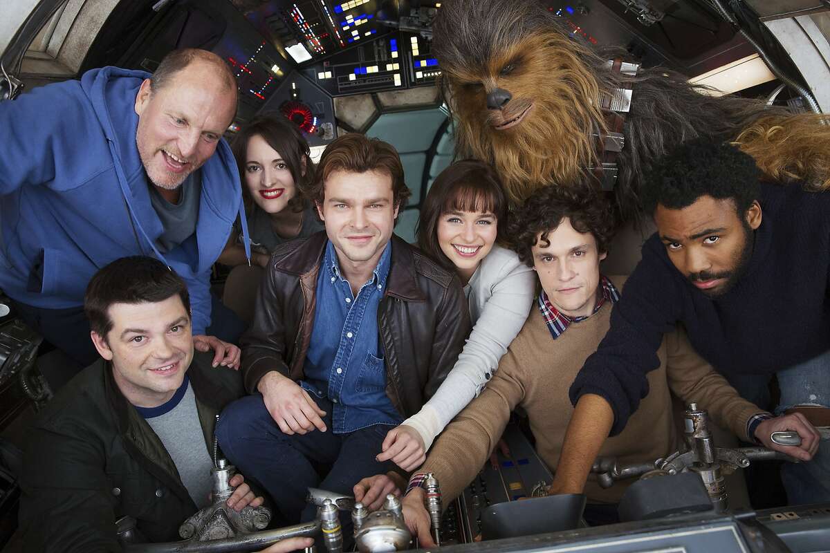 In this undated image provided by Lucasfilm, cast members and co-directors of the Han Solo "Star Wars" spin-off pose for a photo, from bottom left, co-director Christopher Miller, Woody Harrelson, Phoebe Waller-Bridge, Alden Ehrenreich, Emilia Clarke, Joonas Suotamo as Chewbacca, co-director Phil Lord and Donald Glover. The Walt Disney Co. announced Tuesday, Feb. 21, 2017, that shooting began at London's Pinewood Studios on Monday. (Jonathan Olley/Lucasfilm via AP)