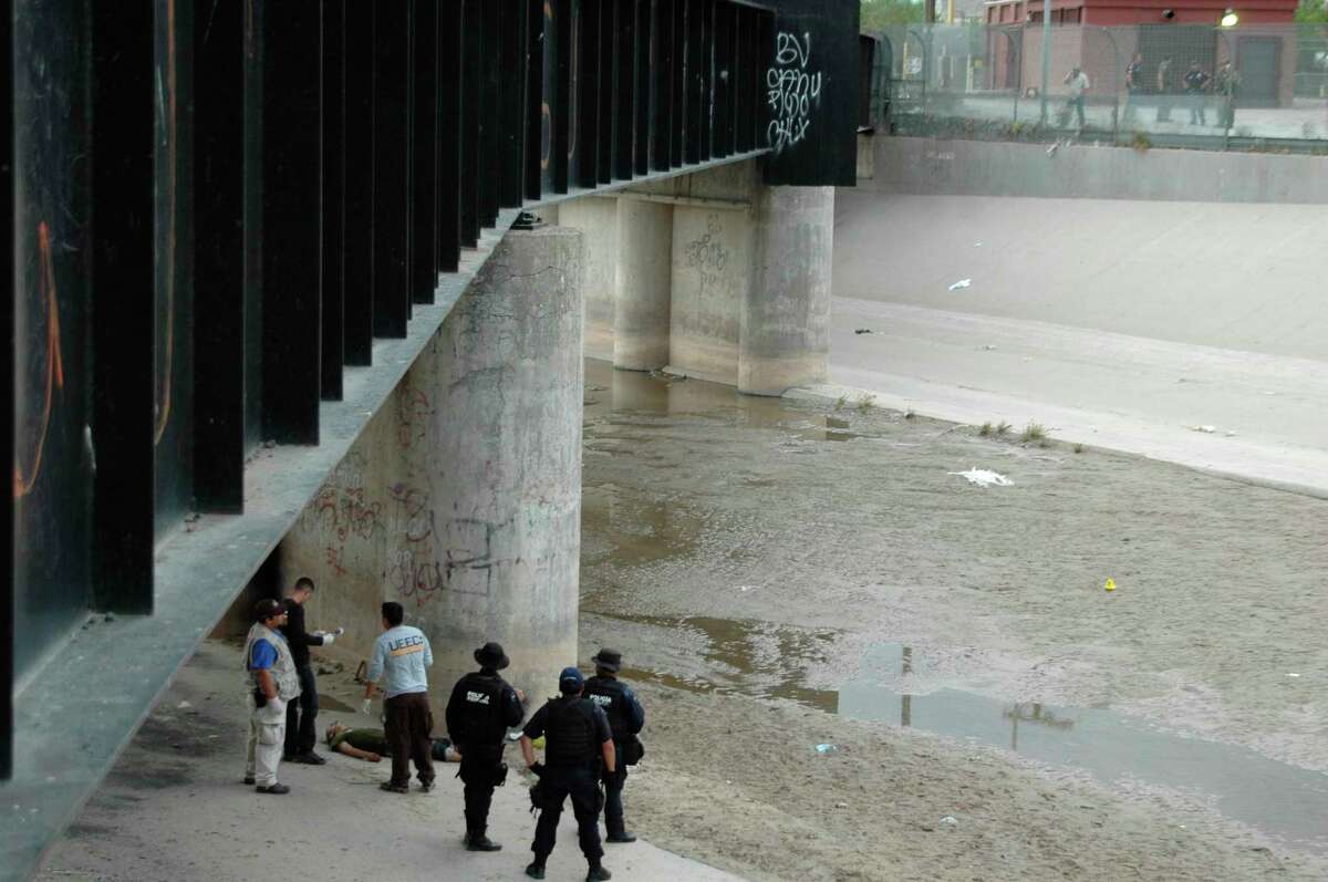﻿Mexican authorities examine the body of Sergio Hernandez under the Paso Del Norte border bridge as U.S. officials, at right, watch in 2010. Some justices described this concrete culvert as a no-man's land.﻿