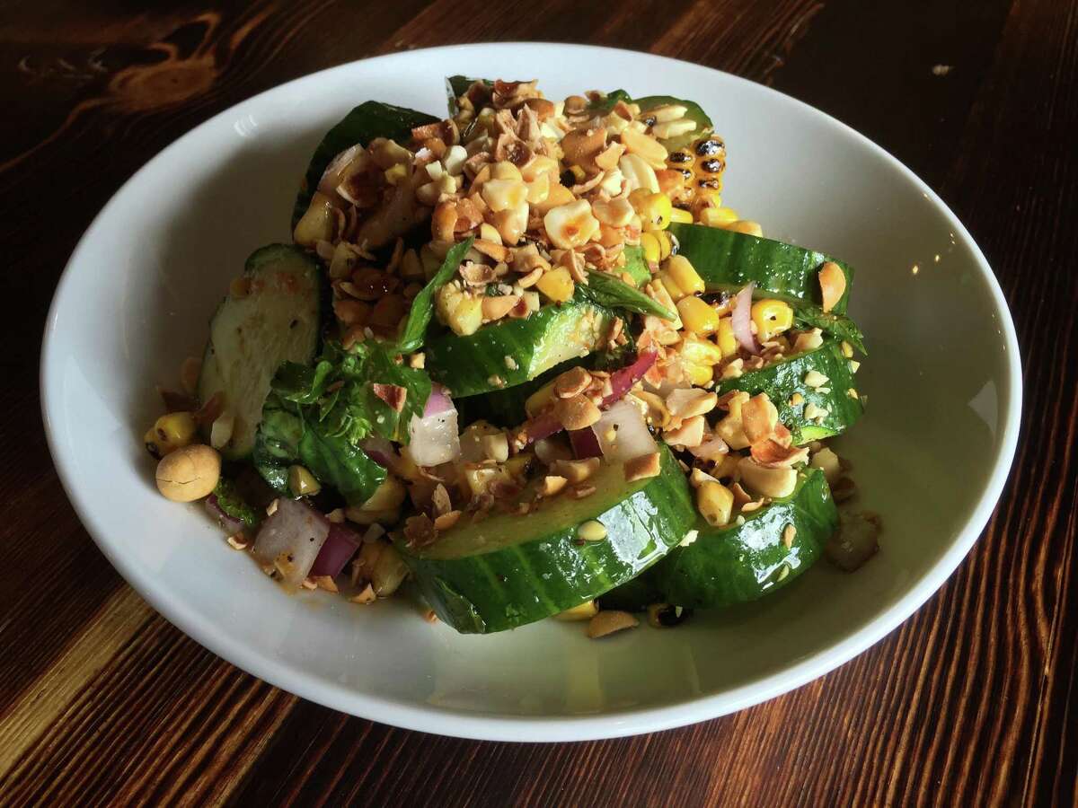 Cucumber appetizer at Alchemy Kombucha and Culture also includes diced red onions, corn, candied peanuts and a drizzle of toasted chile oil.