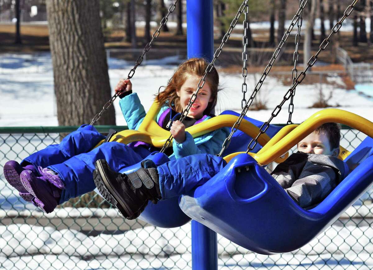Six-year-old Victoria and her 4-year-old brother, Lucas Beauregard, of Niskayuna swing in the sunshine in Central Park Wednesday Feb. 22, 2017 in Schenectady, NY. (John Carl D'Annibale / Times Union)