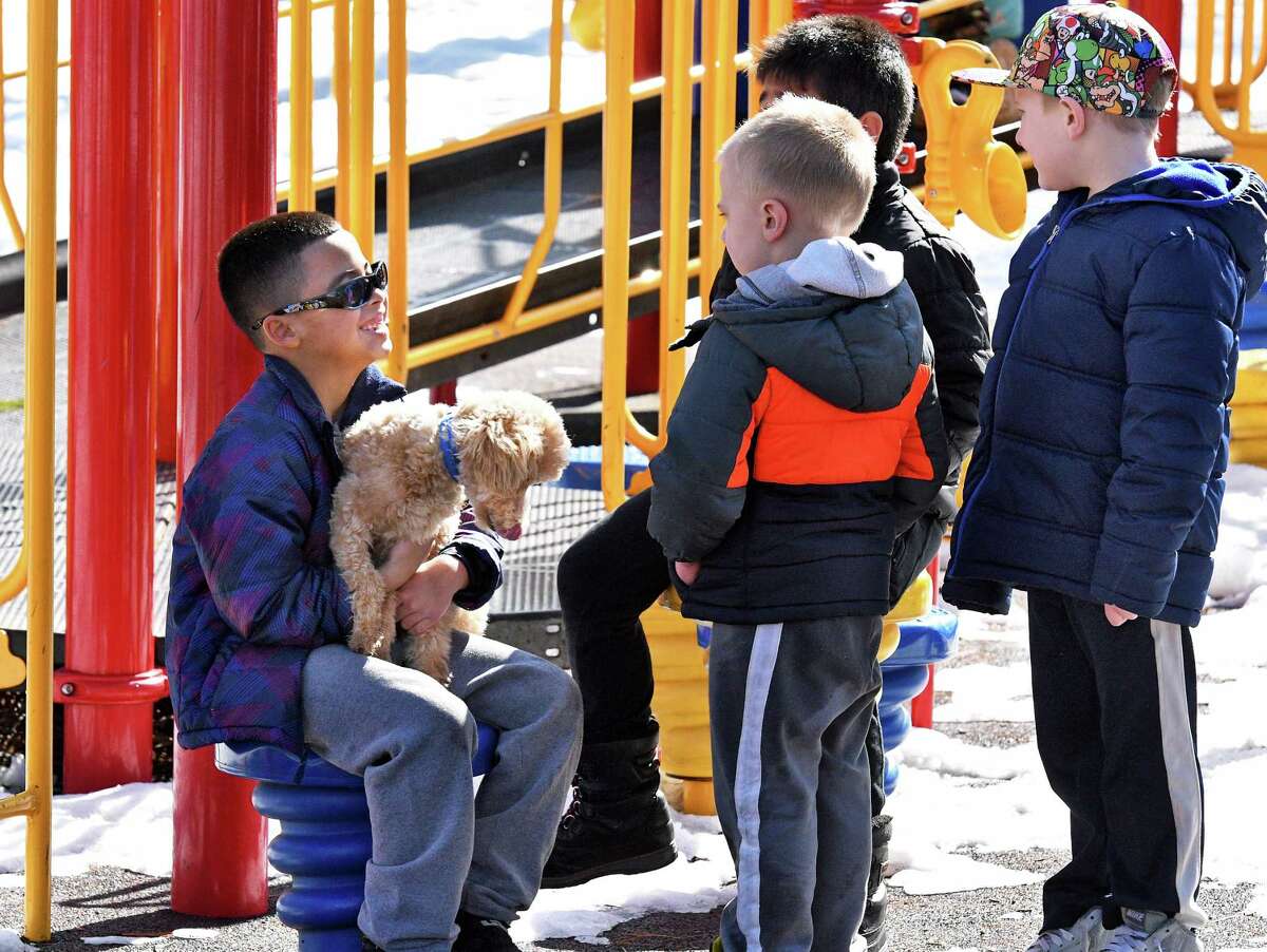 Six-year-old Christopher Gonzalez, left, of Schenectady shows off his new puppy, Coby, to friends in Central Park Wednesday Feb. 22, 2017 in Schenectady, NY. (John Carl D'Annibale / Times Union)