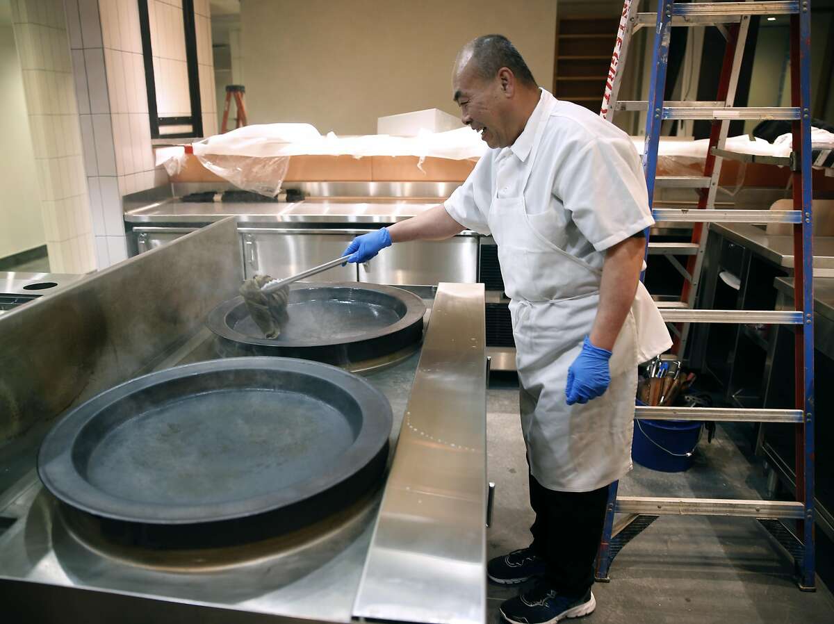 Chef Niu seasons pans used exclusively for shen ziang pork baos as preparation work is in the final stages at China Live in San Francisco, Calif. on Monday, Feb. 20, 2017. George Chen's ambitious project on Broadway Street includes a tea cafe, restaurants and retail space all under one roof.