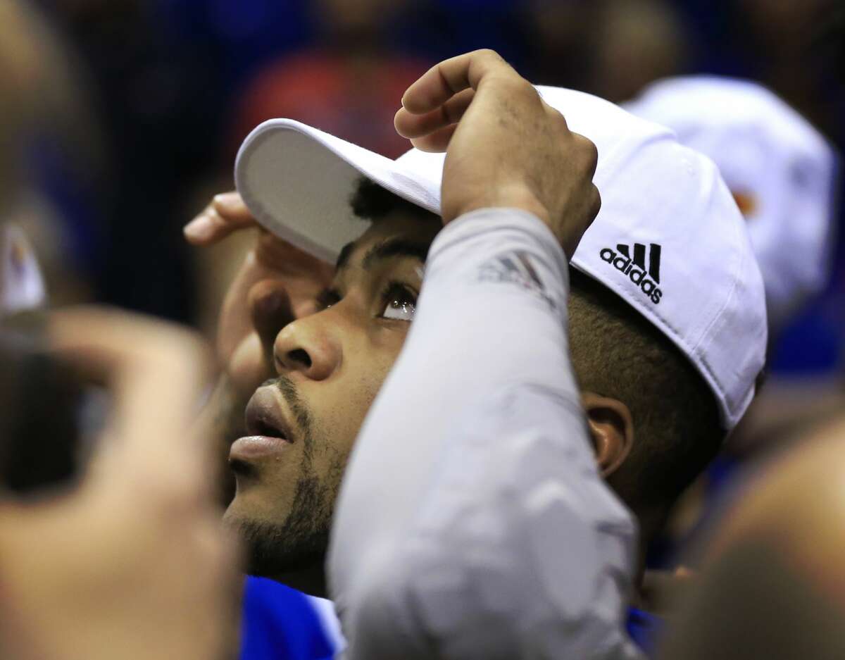 Kansas guard Frank Mason III watches a video while adjusting his Big 12 championship hat following the team's NCAA college basketball game against TCU in Lawrence, Kan., Wednesday, Feb. 22, 2017. Kansas defeated TCU 87-68. The Jayhawks clinched at least a tie for their 13th straight Big 12 title. (AP Photo/Orlin Wagner)