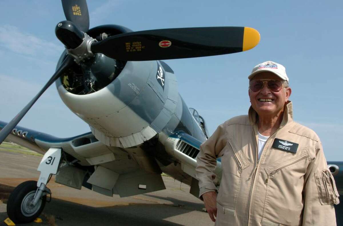 Pilot Andy Michalak, of Virginia Beach, VA, poses by the F4U Corsiar fighter plane he flew, during the Wings and Wheels 2010 car and air show at Sikorsky Memorial Airport in Stratford, Conn. on Saturday May 29, 2010.