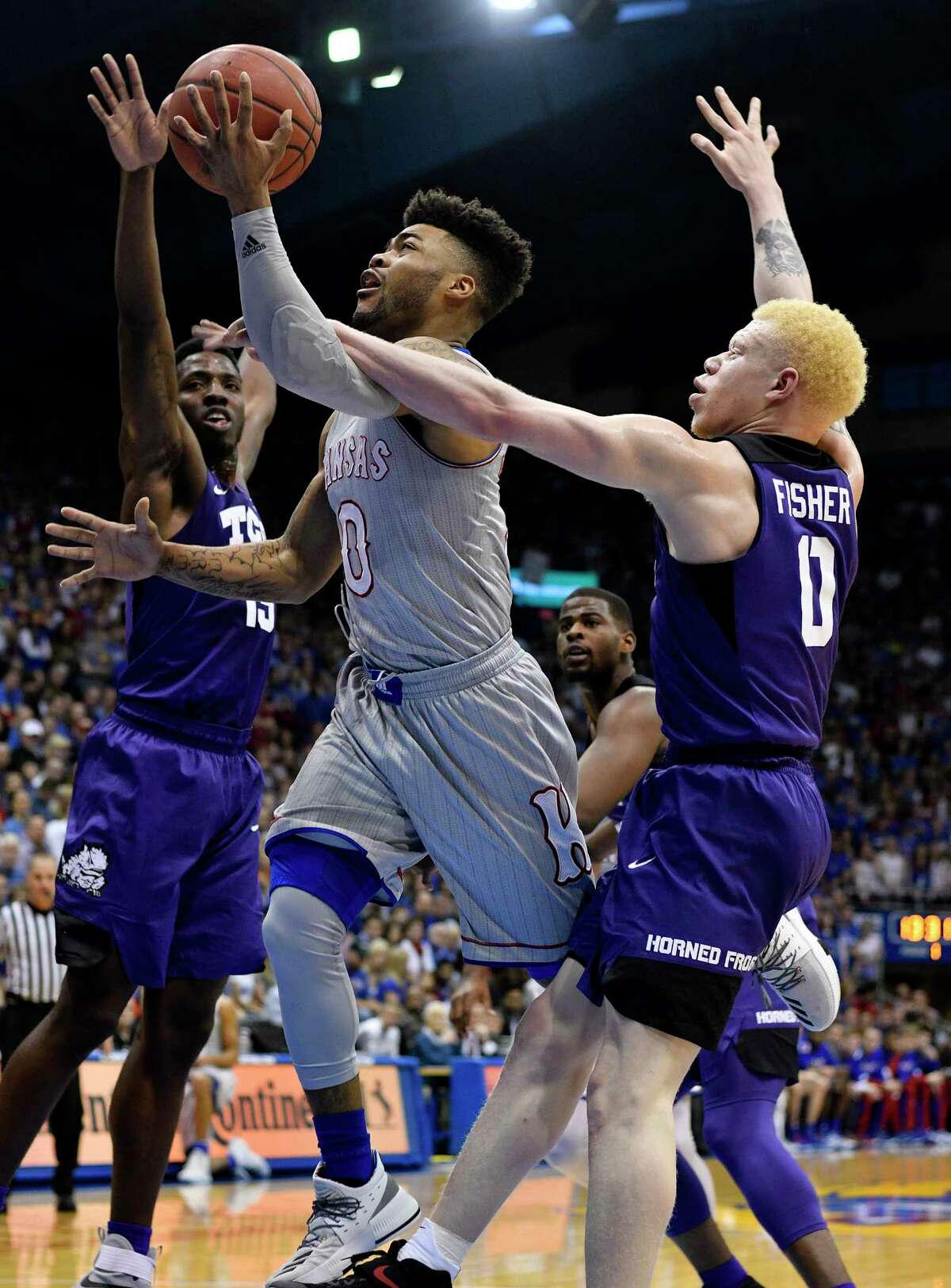 LAWRENCE, KS - FEBRUARY 22: Frank Mason III #0 of the Kansas Jayhawks lays the ball up against JD Miller #15 and Jaylen Fisher #0 of the TCU Horned Frogs in the first half at Allen Fieldhouse on February 22, 2017 in Lawrence, Kansas. (Photo by Ed Zurga/Getty Images) ORG XMIT: 669708613