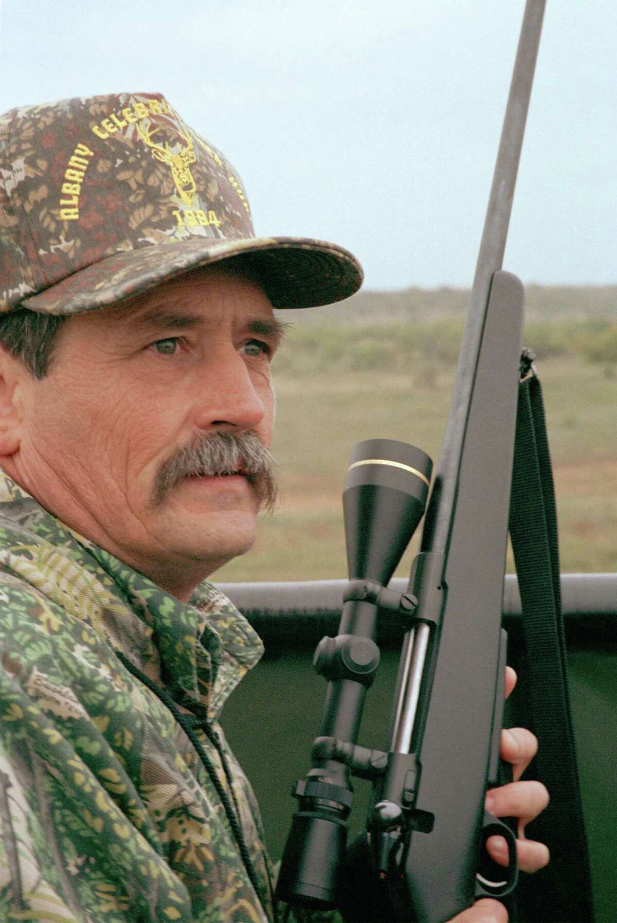 deer hunter with rifle. HOUCHRON CAPTION (10/17/2002): The scoped-action rifle is the overwhelming choice among veteran Texas deer hunters. Note the locked bolt raised into the half-cocked position to serve as visible safety.
