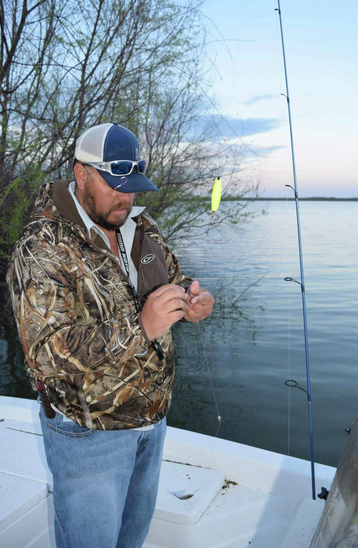 Guide and bait shop owner Bud Council puts together one of his special crappie rigs before tempting spring spawning crappie with minnows in shallow water along the shoreline of Choke Canyon Reservoir.