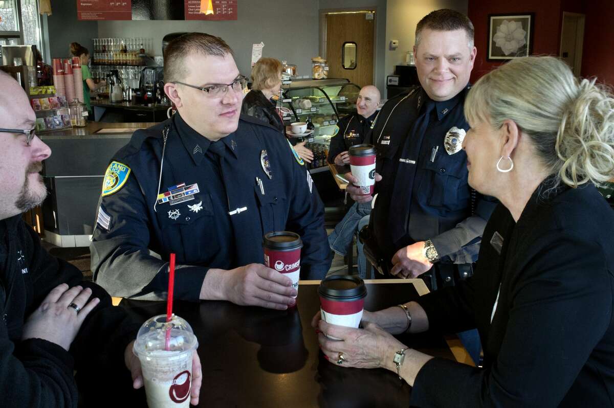 BRITTNEY LOHMILLER | blohmiller@mdn.net Midland residents Jason White, left, and Jody Cooley talk with Midland Police Community Relations Sgt. Chris Wenzell, center, and Officer Jeffrey Krauss at Coffee Chaos Thursday morning during the first Coffee with a Cop. "It's great for the the public to come out and meet the police officers," Cooley said. "And you can voice your concerns directly."