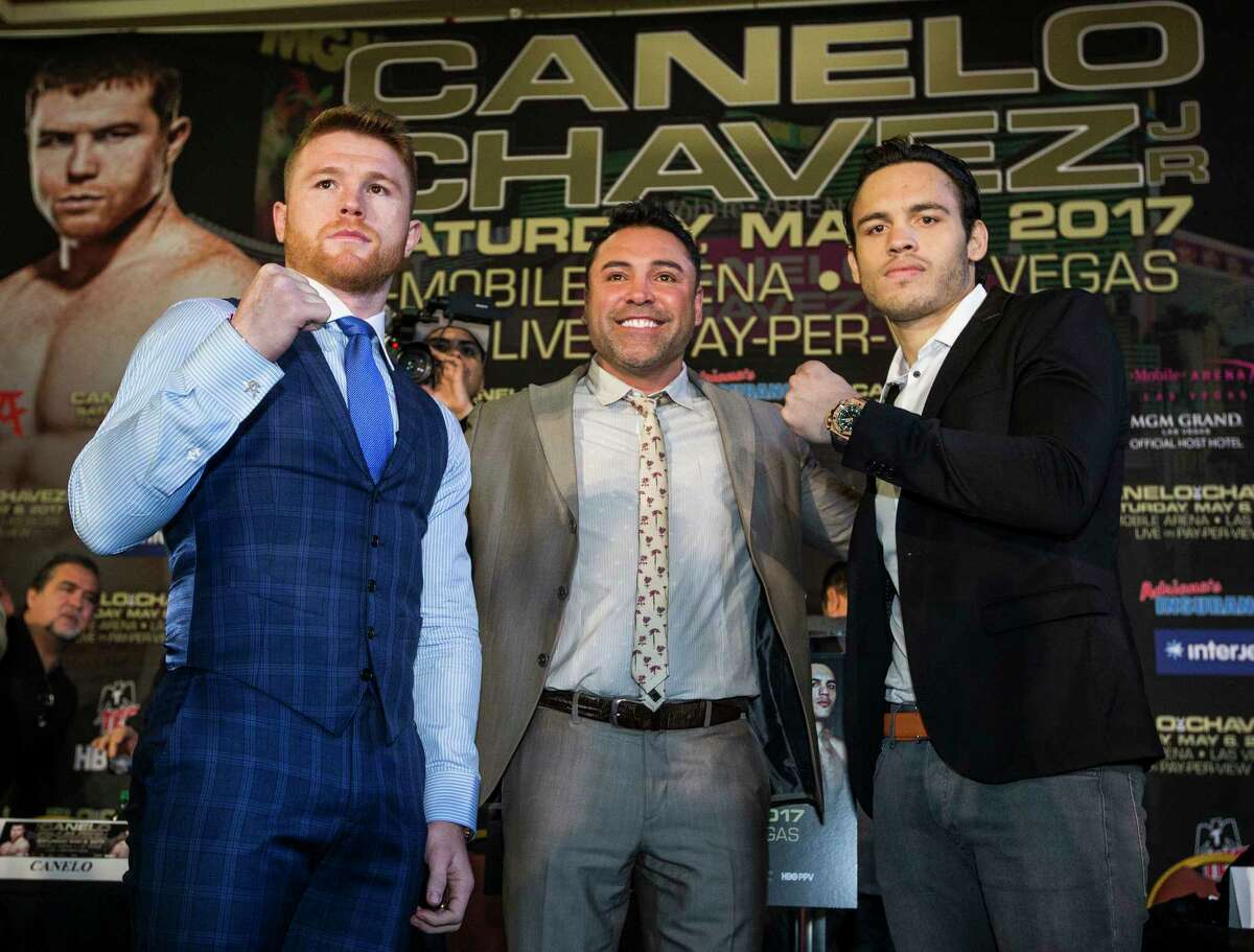 Canelo Alvarez, left, and Julio Cesar Chavez, Jr., pose for photos with Oscar de la Hoya, center, during a news conference promoting the fight between Alvarez and Chavez at Minute Maid Park on Thursday, Feb. 23, 2017, in Houston. The Mexican boxers are scheduled to fight on May 6, 2017, at T-Mobile Arena in Las Vegas.