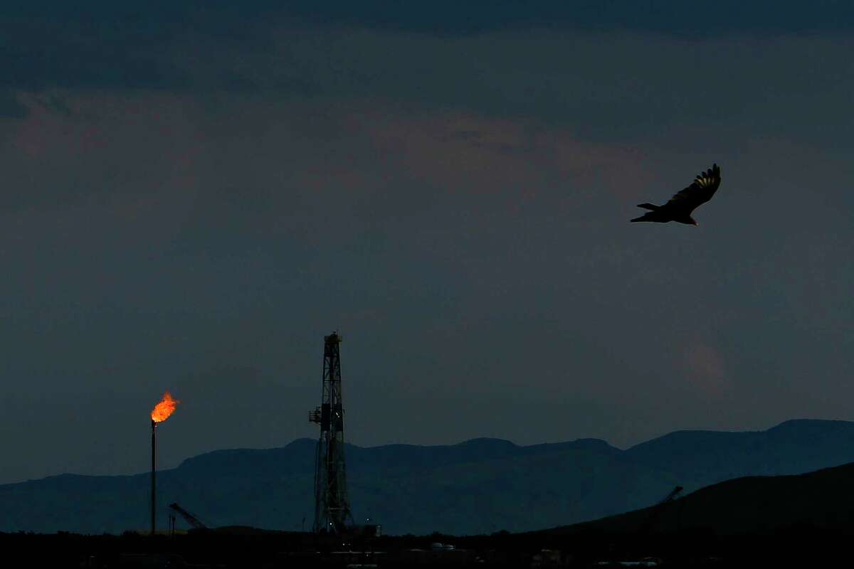 A vulture soars over an Apache Corporation flare and drilling rig north of the Davis Mountains Friday, Sept. 16, 2016 in Balmorhea, TX. The company recently announced the discovery of an estimated 15 billion barrels of oil and gas in the area and plans to drill and use hydraulic fracturing on the 350,000 acres surrounding the town. Apache has leased the mineral rights under the town and nearby state park, but has promised not to drill on or under either. While some residents worry that the drilling could affect the spring at the state park and impact tourism, others are excited for the potential economic boom the oil discovery and drilling could bring.