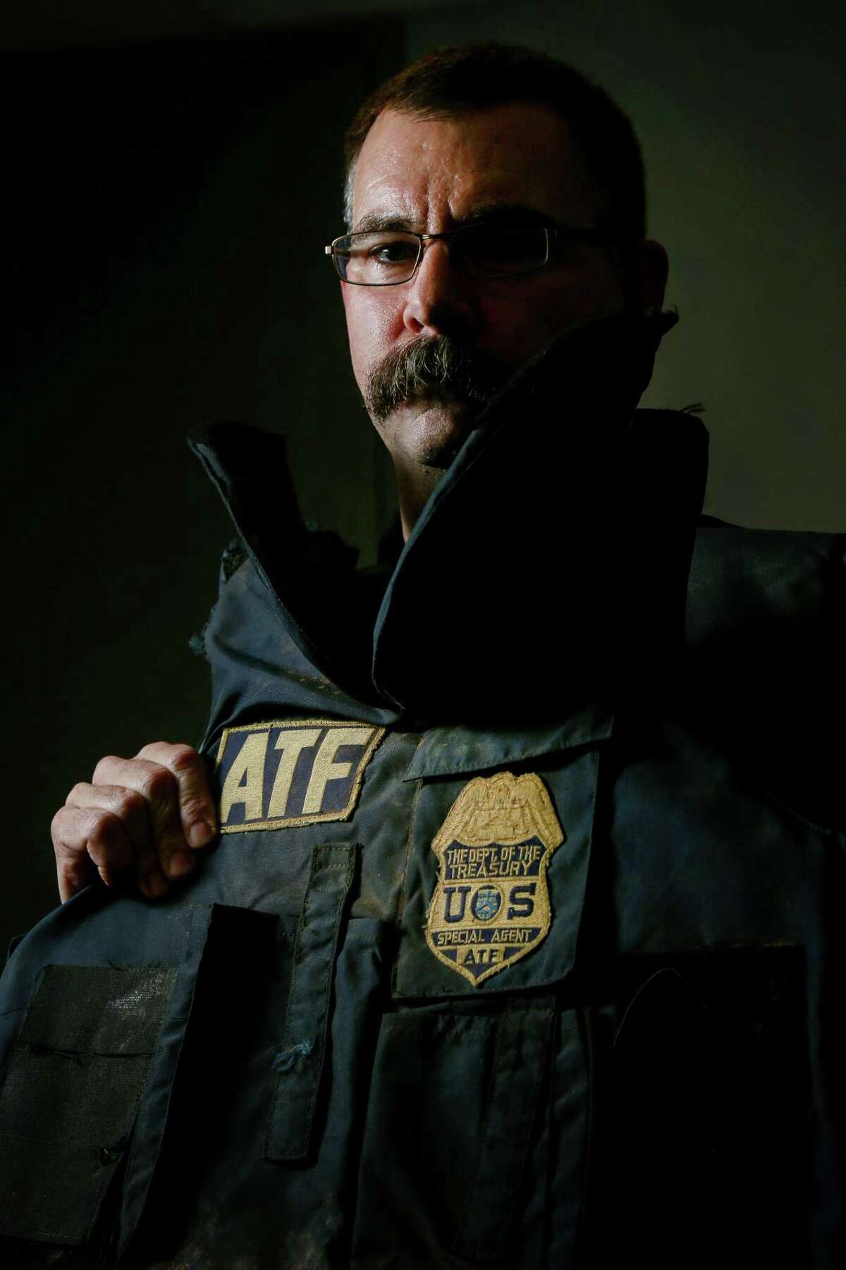 ATF Special Agent Eric Evers poses for a portrait with a body armor vest he wore during the raid on the Branch Davidian compound in 1993, Monday, Jan. 9, 2017, in Houston. The vest stopped three of the five rounds that hit Evers. ( Jon Shapley / Houston Chronicle )