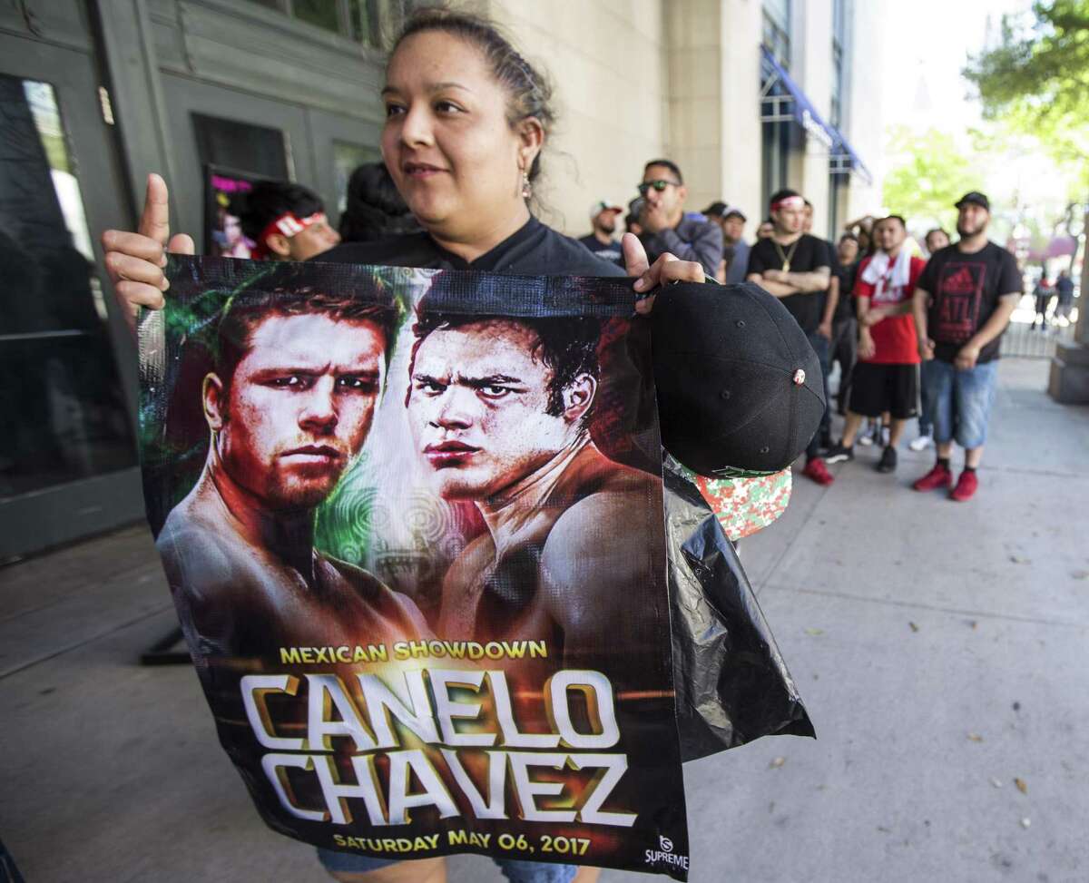 Maria Chavez holds a fight promotion sign as she waits outside Minute Maid Park to attend a press conference promoting the fight between Canelo Alvarez and Julio Cesar Chavez, Jr., on Thursday, Feb. 23, 2017, in Houston. ( Brett Coomer / Houston Chronicle )