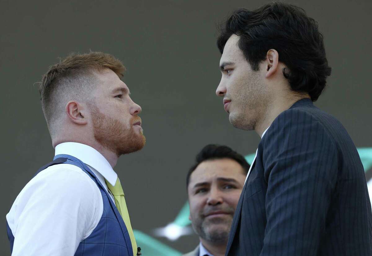 Mexican boxers Saul "Canelo" Alvarez, left, and Julio Cesar Chavez Jr., are presented during a press conference in Mexico City, Monday, Feb. 20, 2017. Alvarez and Chavez were face-to-face for the first time Monday, the first stop on a promotional tour of their May 6th Las Vegas showdown. Pictured in background is Hall of Fame boxer Oscar De La Hoya. (AP Photo/Marco Ugarte)
