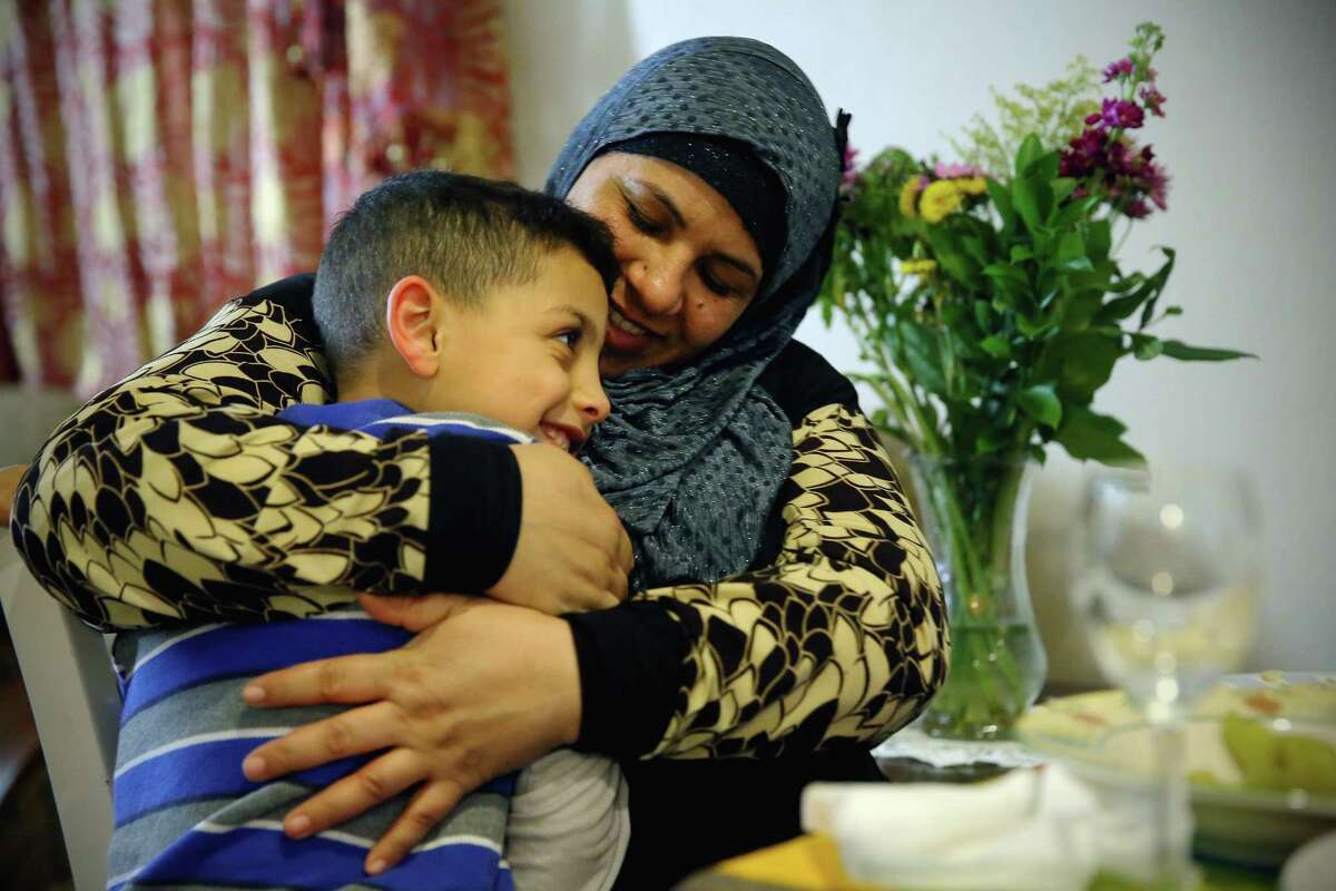 Rabah Saleh talks with her youngest son Ahmad, 7, Feb. 14, 2017. Since fleeing from Syria to the U.S. via Jordan one year ago, she has started working part time as a janitor at a local school in West Seattle.