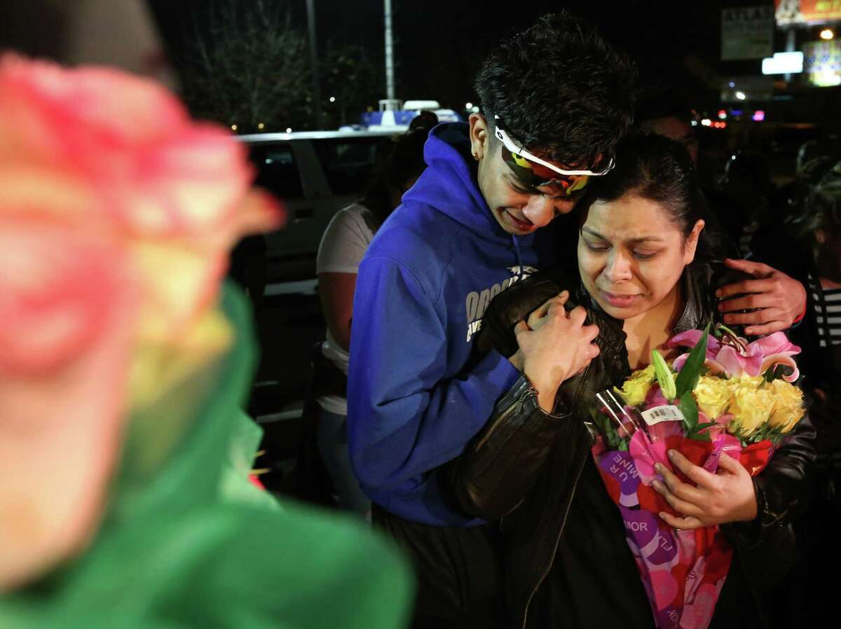 Max Vasquez, brother of 18-year-pold Subway employee Javier Flores, and his mother put flowers at the make-shift memorial at the vigil prepared for Flores Thursday, Feb. 23, 2017, in Houston. Flores tried to get between an armed robber and his mother, another employee, and was killed.