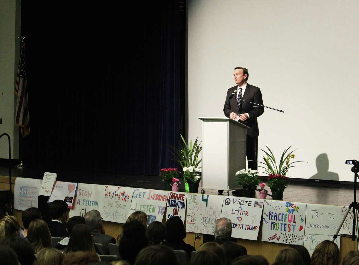 Sen. Christopher Murphy, D-Conn., speaks on a stage lined with GIVE Campaign student signs during a town hall meeting organized by the group at Fairfield Ludlowe High School in Fairfield, Conn. on Feb. 23, 2017.