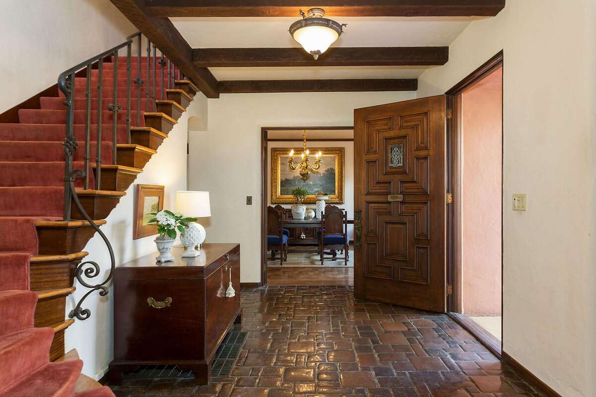 The foyer offers a tile floor, beamed ceiling and turned staircase.
