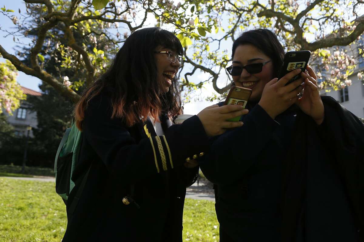 Pam Patino, left, and Beatriz Israde, right, first year students at University of California, Berkeley takes a picture of flowers using their cell phones on Friday, Feb. 24, 2017, in Berkeley, Calif.