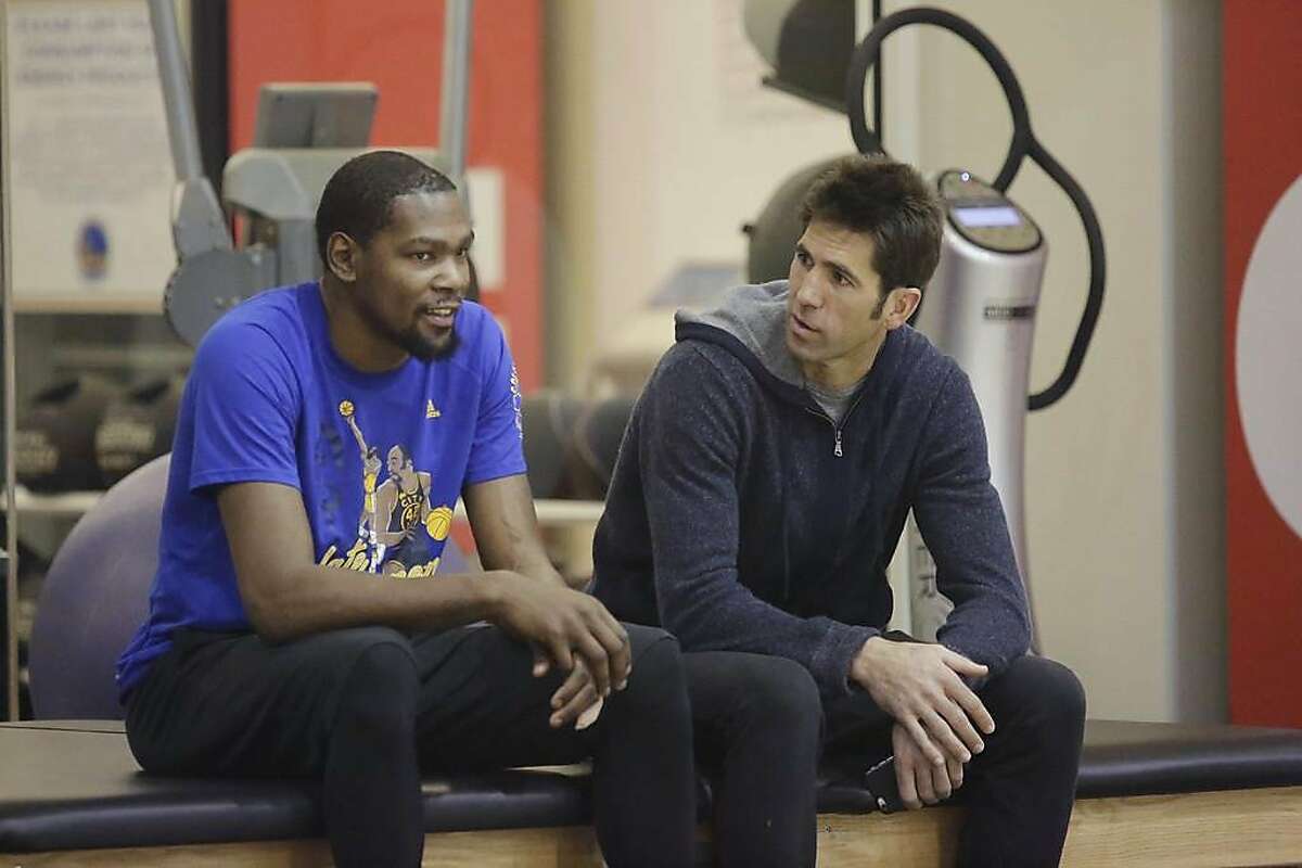 Kevin Durant (l to r) and Bob Myers, Golden State Warriors general manager, talk during a Warriors' practice session on Friday, February 24, 2017 in Oakland, Calif.