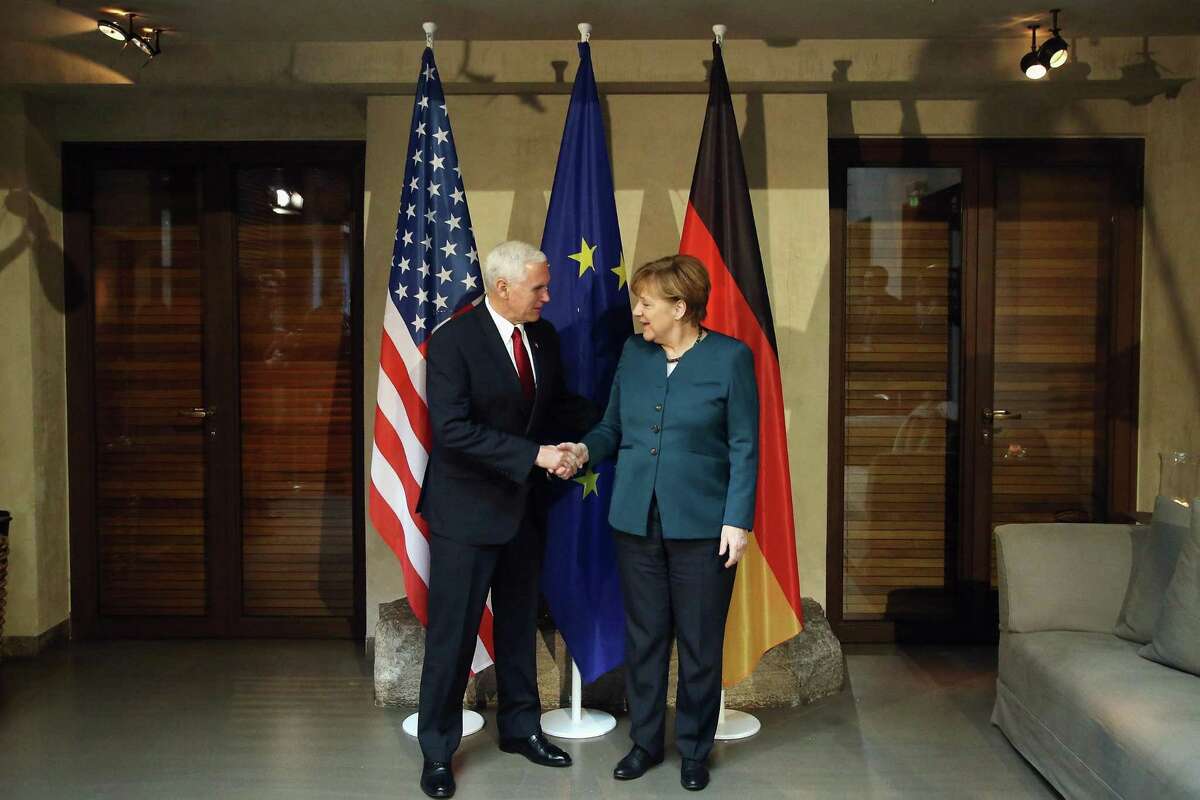 U.S. Vice President Mike Pence and German chancellor Angela Merkel shake hands at the 2017 Munich Security Conference on Feb. 8 in Munich, Germany. There may be a useful strategy in having an unpredictable president but grownups in the cabinet who, together, can play good cop, bad cop.