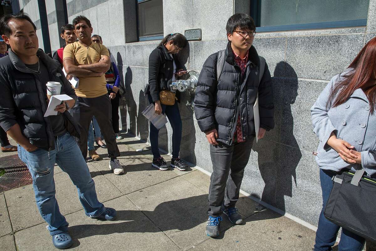 Second from right: Mike Lee, from South Korea, and others wait in line to go inside the U.S. Citizenship & Immigration Service building located at 630 Sansome Street on Thursday, Feb. 23, 2017, in San Francisco, Calif. Lee, a molecular biology student at UC Berkeley, said he was going in for a naturalization interview.