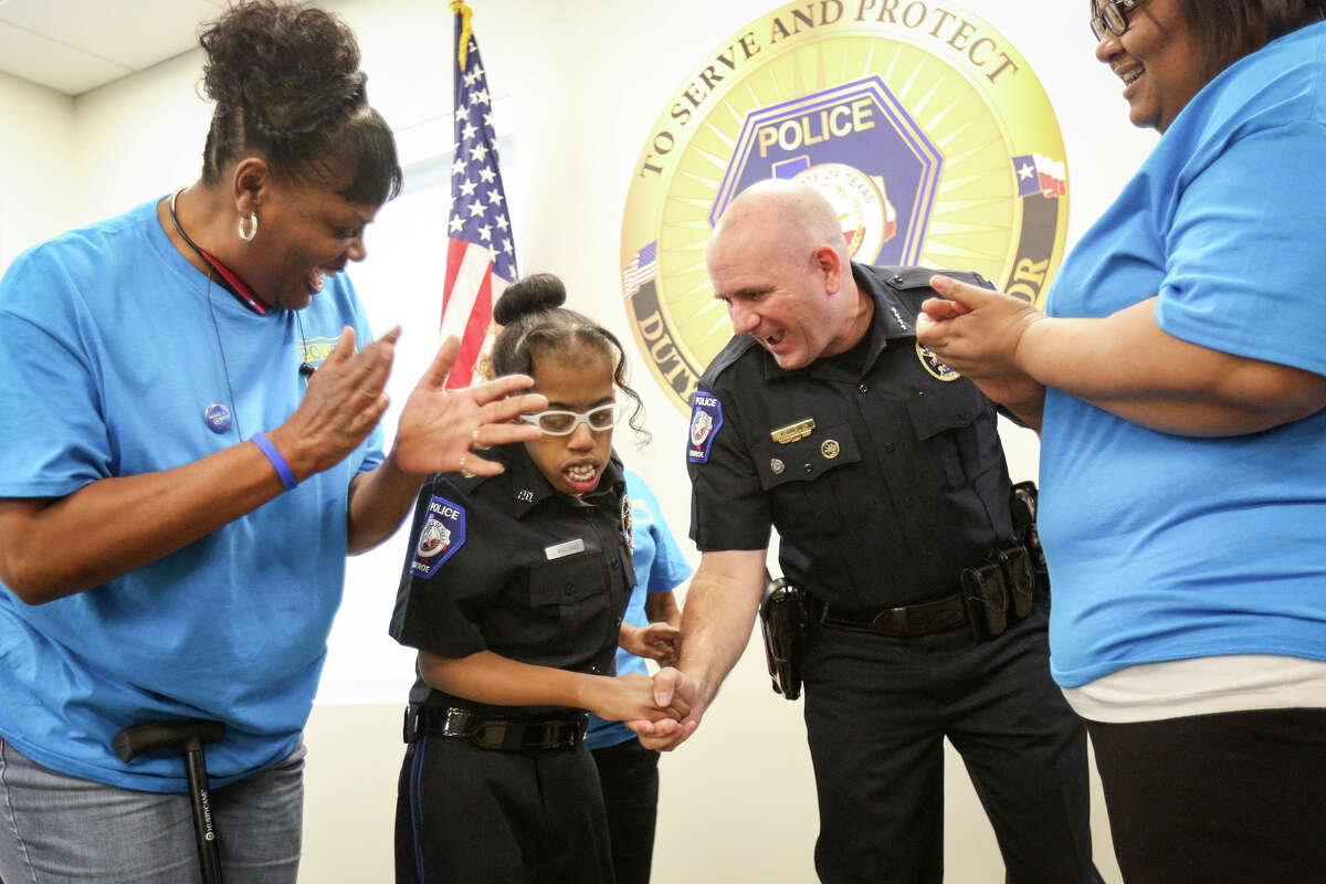 Make-A-Wish recipient Lauryn Williams is sworn in as an honorary Conroe police officer by Philip Dupuis, Conroe Chief of Police, as her grandmother Jackie Anderson and mother LaCoshia Williams applaud on Monday, Nov. 14, 2016, at the Conroe Police Department.