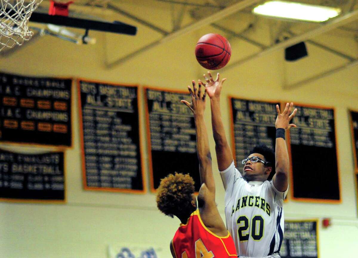 Notre Dame of Fairfield’s Nori Davis releases a shot over Stratford’s Prince Carter during Friday’s SWC quarterfinal.