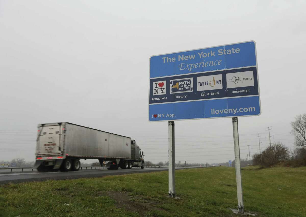 A truck passes a sign for "I Love New York" and other state attractions on the New York State Thruway, Tuesday, Nov. 29, 2016, in Utica, N.Y. Officials with the Federal Highway Administration say the signs don't conform to federal standards and pose a dangerous distraction for motorists. (AP Photo/Mike Groll)