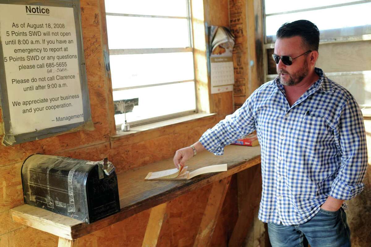 Tim Greer of Lenorah Operators, points out a copy book and a mailbox where drivers record and file their stops at a wastewater recycling well located south of Midland.