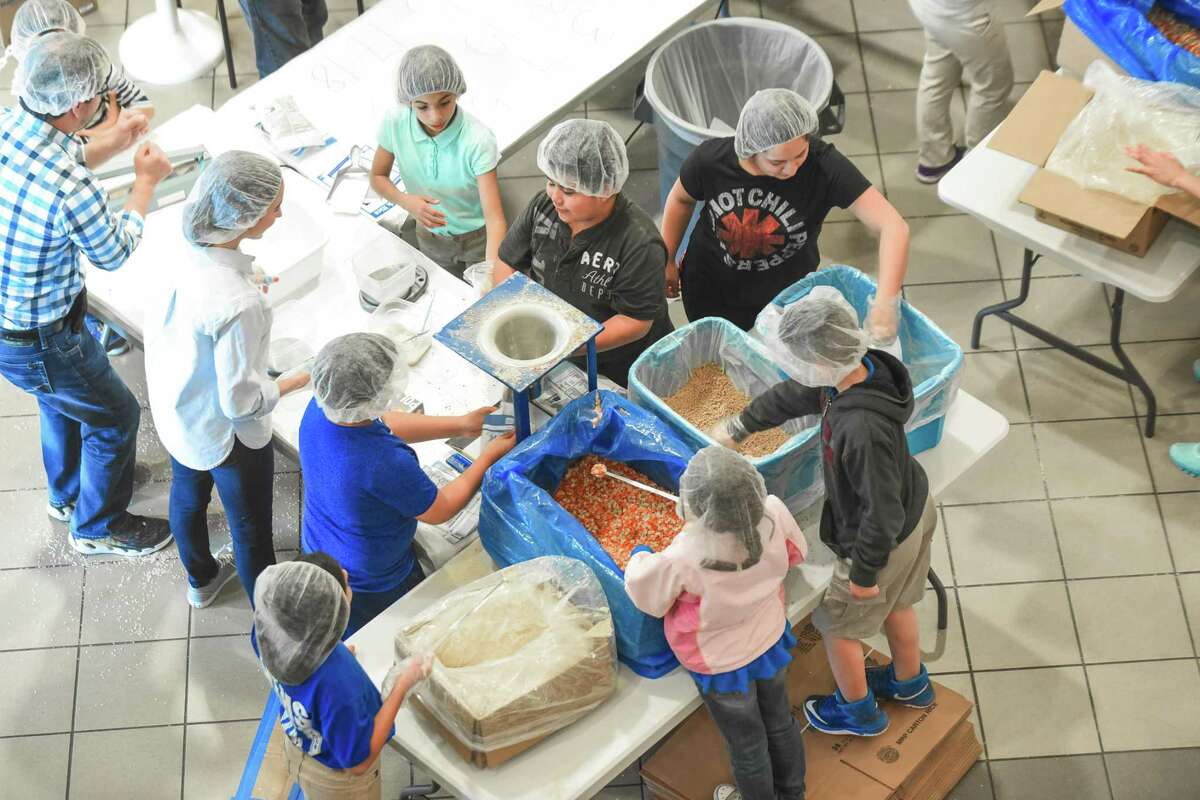 Voluntarios preparan paquetes de comida durante el programa Feed My Starving Child MobilePack el sábado, en el Centro Estudiantil de TAMIU.