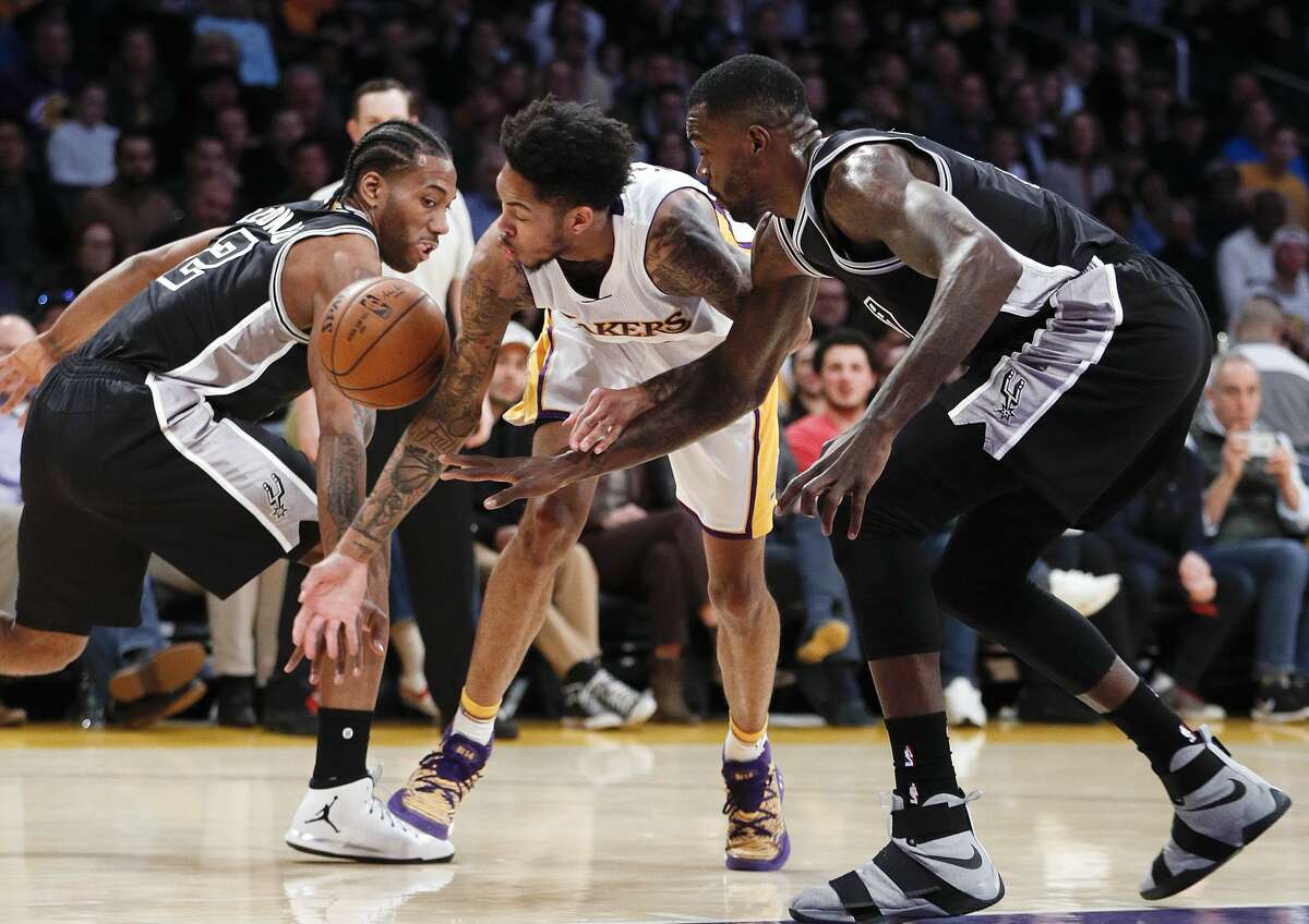 Los Angeles Lakers' Brandon Ingram, center, fights for the ball with San Antonio Spurs' Kawhi Leonard, left, and Dewayne Dedmon during the first half of an NBA basketball game, Sunday, Feb. 26, 2017, in Los Angeles. (AP Photo/Jae C. Hong)