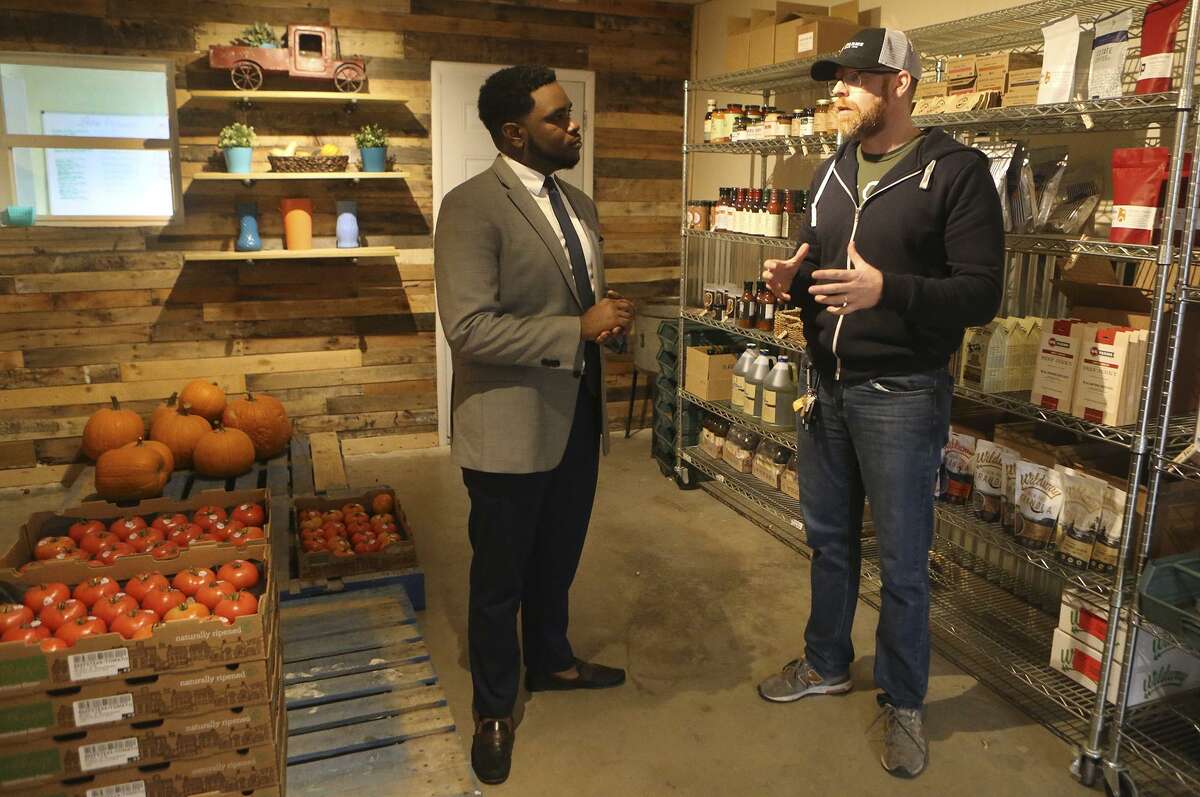 Akeem Brown, (left) Director of Operations for Sage (San Antonio for Growth on the East Side), is pushing for development and progress on San Antonio's East Side. Brown is brokering deals to attract business and commerce on the East Side, and helping small business owners such as Shaun Lee (right), owner of Truckin' Tomato. Truckin' tomato is part of group of businesses under the umbrella name of Local Sprout Food Hub.