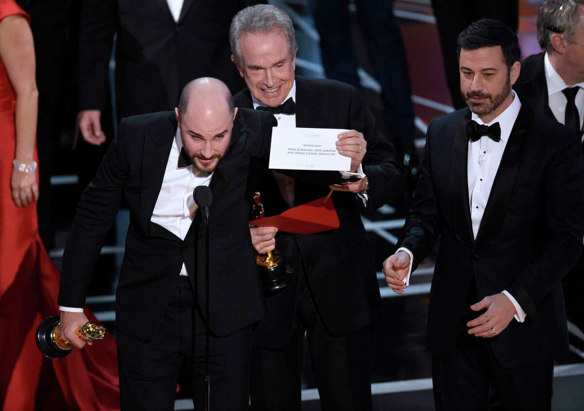 Jordan Horowitz, producer of "La La Land," shows the envelope revealing "Moonlight" as the true winner of best picture at the Oscars on Sunday, Feb. 26, 2017, at the Dolby Theatre in Los Angeles. Presenter Warren Beatty and host Jimmy Kimmel look on from right. (Photo by Chris Pizzello/Invision/AP)