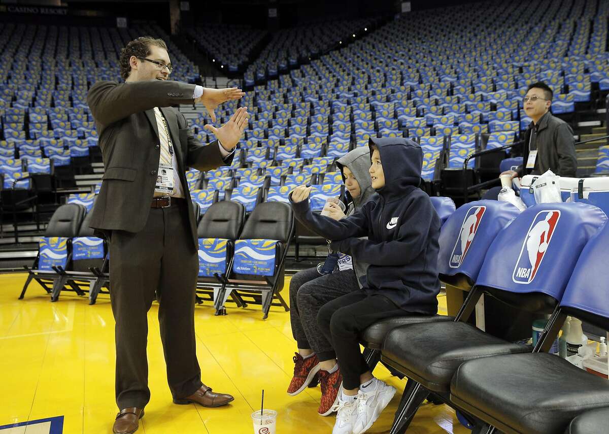 Warriors Manager of Basketball Analytics Sammy Gelfand, left, chats with Davit Pachulia, 8, center, and Saba Pachulia, 7, right, before the Golden State Warriors played the Los Angeles Clippers at Oracle Arena in Oakland, Calif., on Thursday, February 23, 2017.