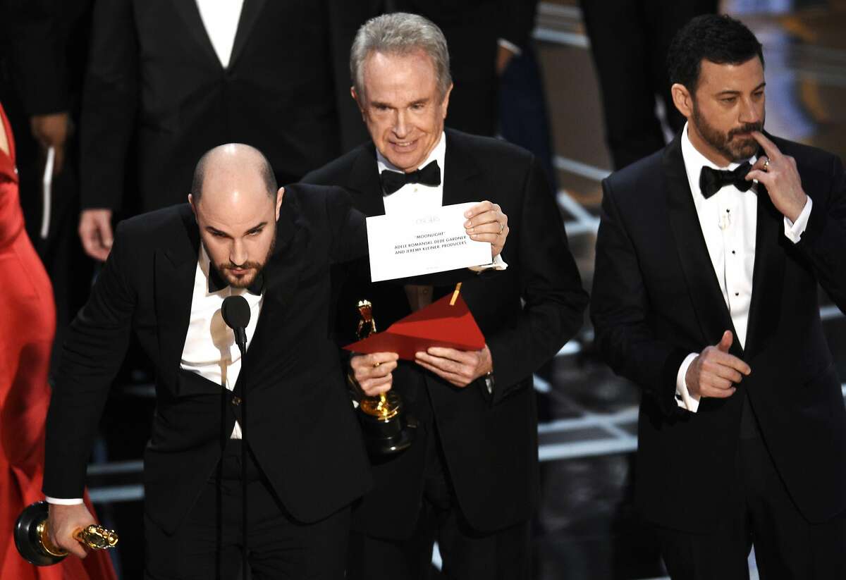 Jordan Horowitz shows the envelope revealing "Moonlight" as the true winner of best picture at the Oscars on Sunday, Feb. 26, 2017, at the Dolby Theatre in Los Angeles. Host Jimmy Kimmel and presenter Warren Beatty look on from right. (Photo by Chris Pizzello/Invision/AP)