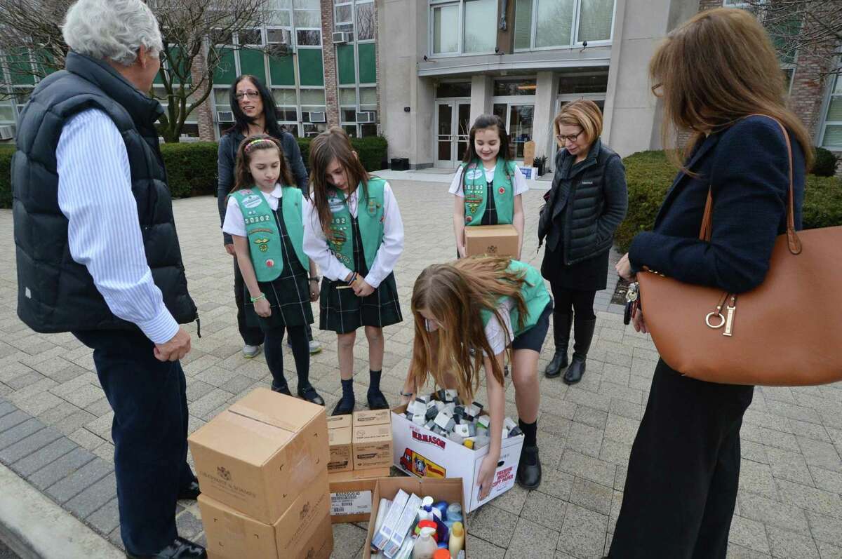 At All Saints Catholic School, the Girl Scouts from Troop 50302 who just earned their Bronze Award for creating a program to reduce waste in the hospitality industry and help the less fotunate carry the donations out. They collected and delivered unused toiletries such as soap and shampoo and pass them on to people that need them through the group Kids in Crisis' Kristen Tomasiewicz and Andrea Arnold and Corky Stewart and Erin McDonough with the Open Door Shelter. on Monday February 27, 2017 in Norwalk conn.