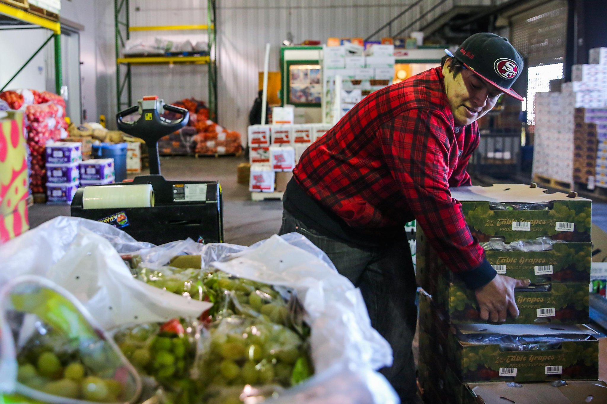 Shoppers examine fruits and vegetables sold at a local Soq