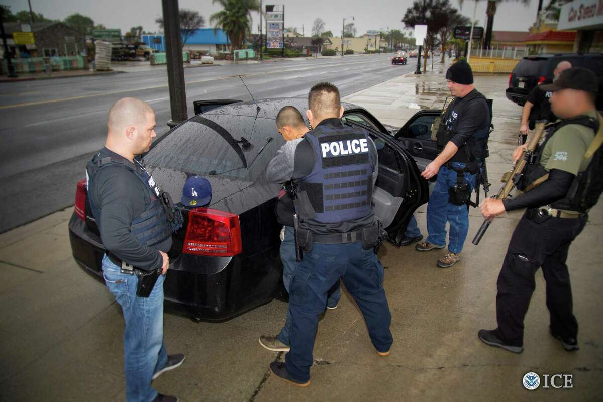 Immigration and Customs Enforcement officers detain a suspect in Los Angeles. A reader says immigration laws should be enforced.