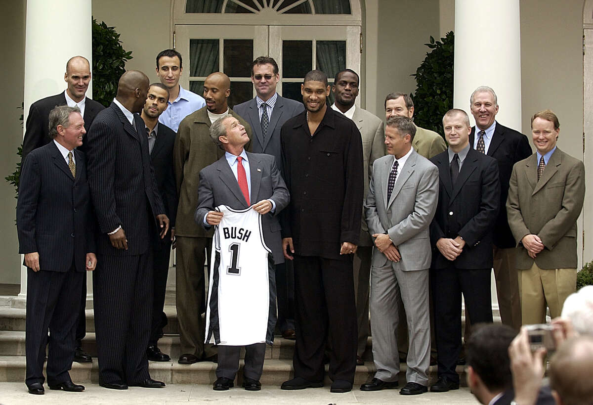 President Bush poses for a group photo with the NBA Champion San Antonio Spurs during a ceremony in the Rose Garden of the White House Tuesday, Oct. 14, 2003. Left to right are team owner Peter Holt, Danny Ferry, Kevin Willis, Tony Parker, Emanuel Ginobili, Bruce Bowen, Bush, general manager R. C. Buford, Tim Duncan, Malik Rose, assistant coaches Brett Brown, foreground, and P.J Carlesimo, trainer Will Sevening, head coach Gregg Popovich and assistant coach Mike Budenholzer. (AP Photo/Gerald Herbert) President Bush poses with the NBA champion San Antonio Spurs at the White House on Tuesday. From left: owner Peter Holt, Danny Ferry, Kevin Willis, Tony Parker, Emanuel Ginobili, Bruce Bowen, Bush, manager R. C. Buford, Tim Duncan, Malik Rose, coach Brett Brown, foreground, and P.J Carlesimo, trainer Will Sevening, coaches Gregg Popovich and Mike Budenholzer.