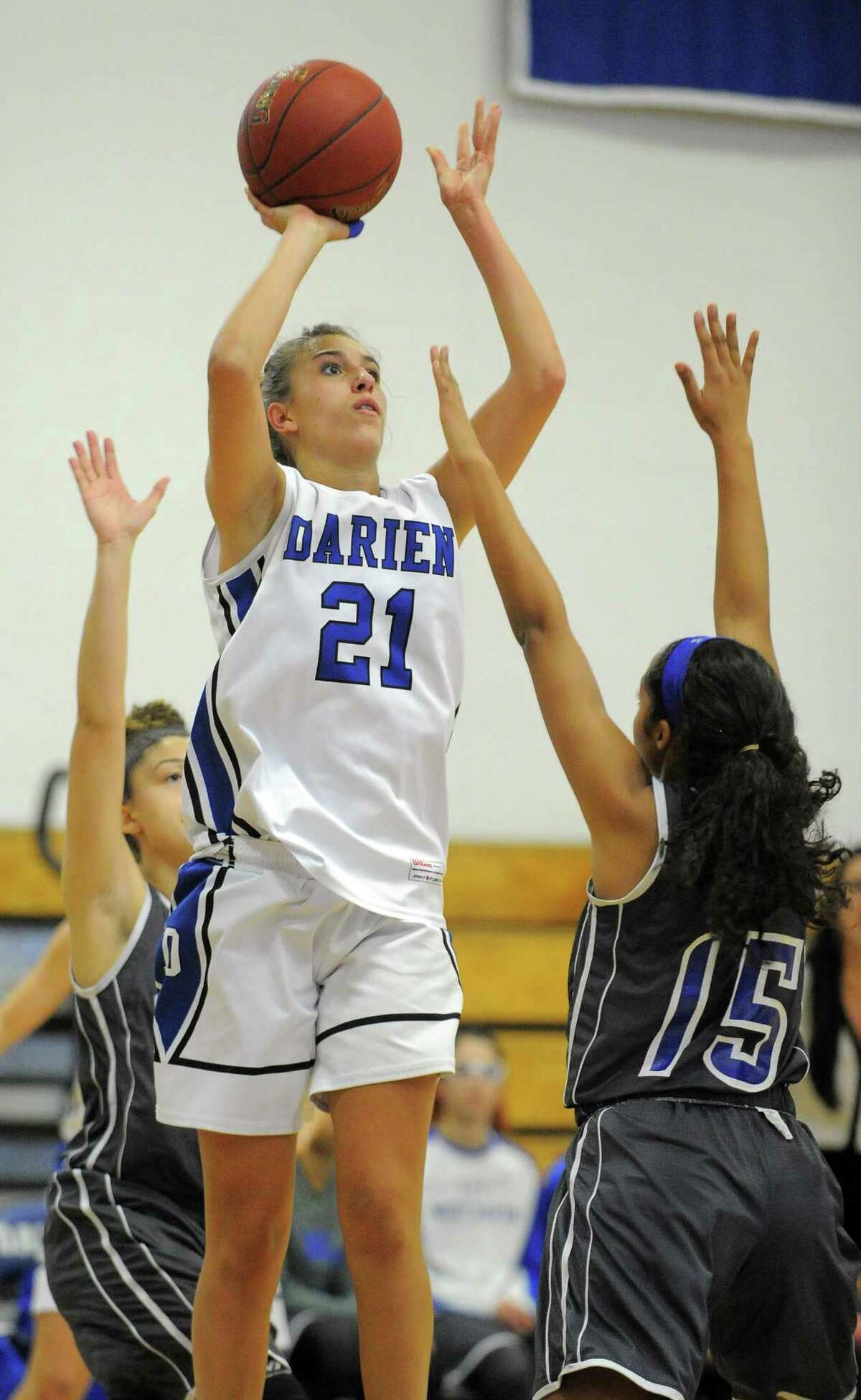 Darien’s Christine Fiore (21) puts up a shot over West Haven’s Lauren Lewis (15) in a CIAC Class LL girls basketball state qualifier at Darien High School on Friday.