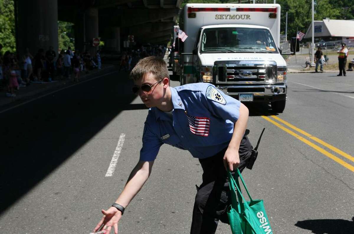 Seymour EMT Joshua Wood throws candy to children while marching in the Seymour Memorial Day parade on Sunday morning.