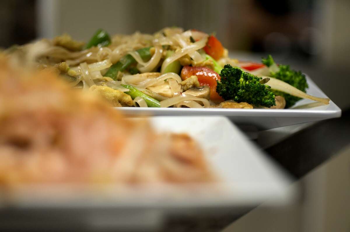 BRITTNEY LOHMILLER | blohmiller@mdn.net Pad Thai chicken, left, and drunken noodles with vegetables wait to be delivered to lunch time patrons at the new downtown location of Basil Thai Bistro Wednesday afternoon.