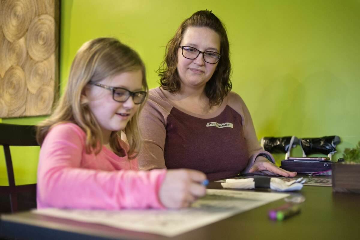 BRITTNEY LOHMILLER | blohmiller@mdn.net Eight-year-old Kendal Buckler, left, and her mother Jocey Buckler look at Basil Thai Bistro's menus during the restaurant's opening day at the new location on 416 E. Ellsworth St. in downtown Midland.