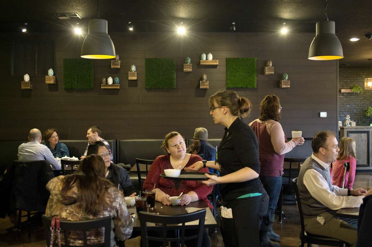 BRITTNEY LOHMILLER | blohmiller@mdn.net Basil Thai Bistro assistant manager Jaime DesJardin takes lunch orders from restaurant patrons during the opening day of Basil Thai Bistro's new location on 416 E. Ellsworth St. in downtown Midland.