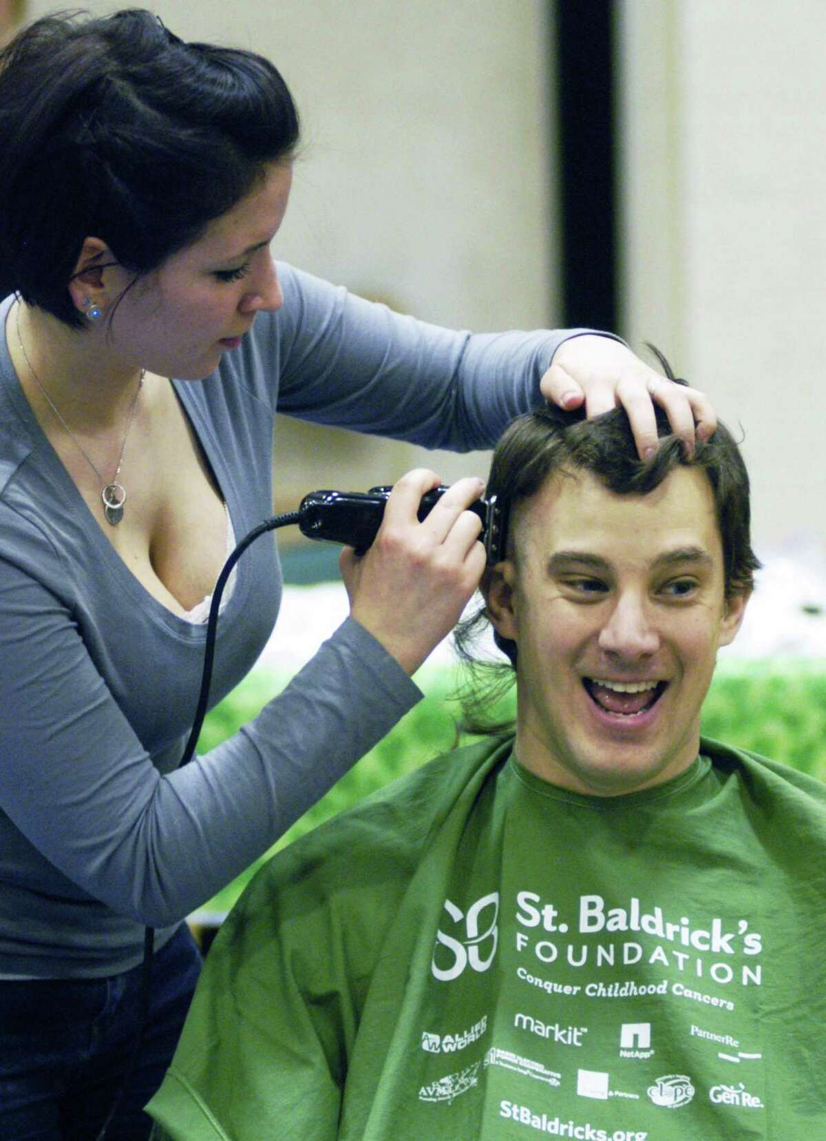 Nicole Spaziani trims the locks of affable assistant principal Dr. Christopher Longo during New Milford's High School's St. Baldrick's Foundation head-shaving fundraiser, March 16, 2015