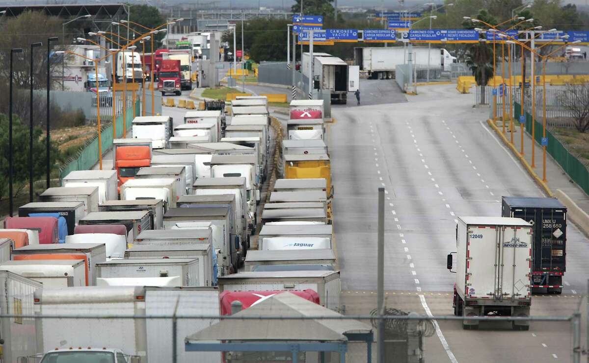 File photo of two trucks, right, leaving the U.S. as a long line of trucking traffic waits to enter the U.S. from Mexico at the World Trade Bridge in Laredo, TX, on Friday, Jan. 27, 2017. President Donald Trump, within his first week in office, floated the idea for a 20 percent tariff on Mexican goods that sent executives here and across the border scrambling to fend off the attack. The tariff idea never went any where, but animosity between the U.S. and Mexico increased throughout the year as Trump moved forward with plans to build a border wall between the two nations and to renegotiate NAFTA.