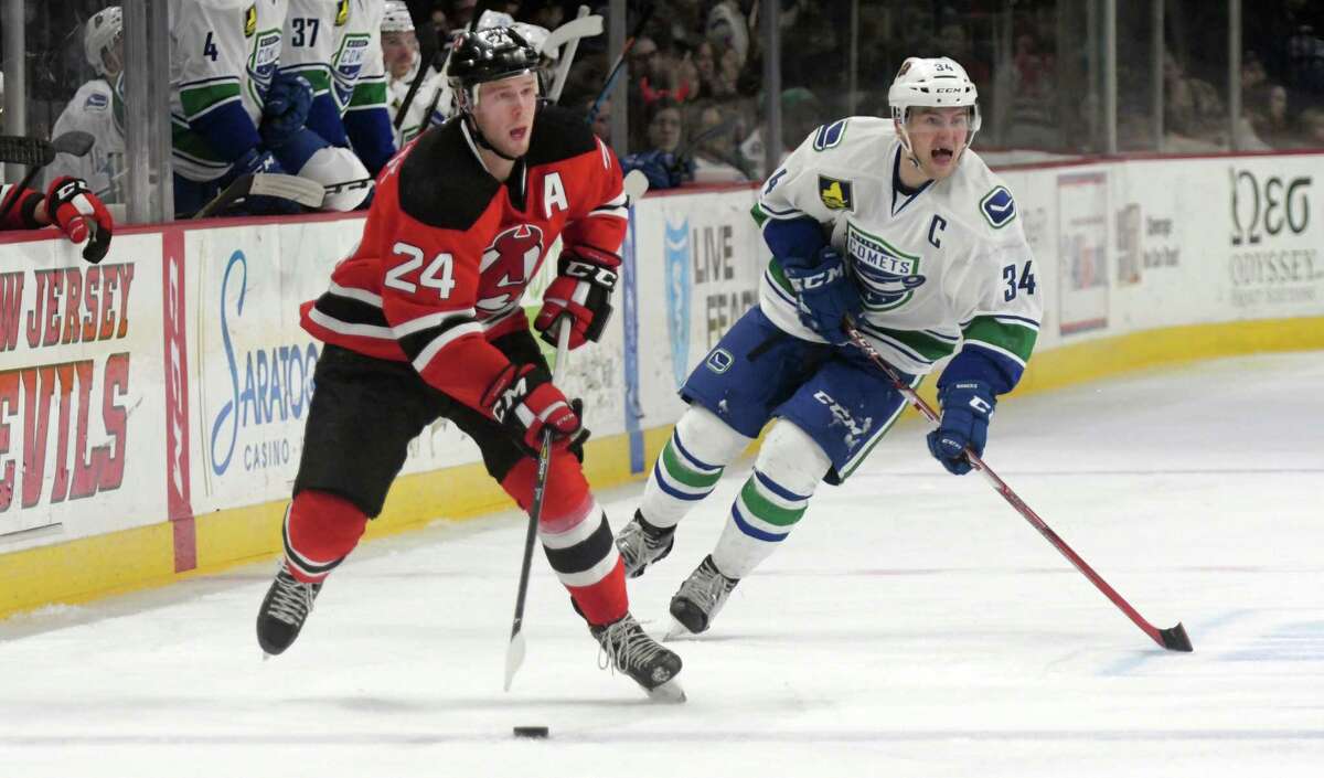 Albany Devils Reece Scarlett, left, brings the puck up the ice as Utica Comets Carter Bancks chases during their game on Monday, Feb. 20, 2017, in Albany, N.Y. (Paul Buckowski / Times Union)